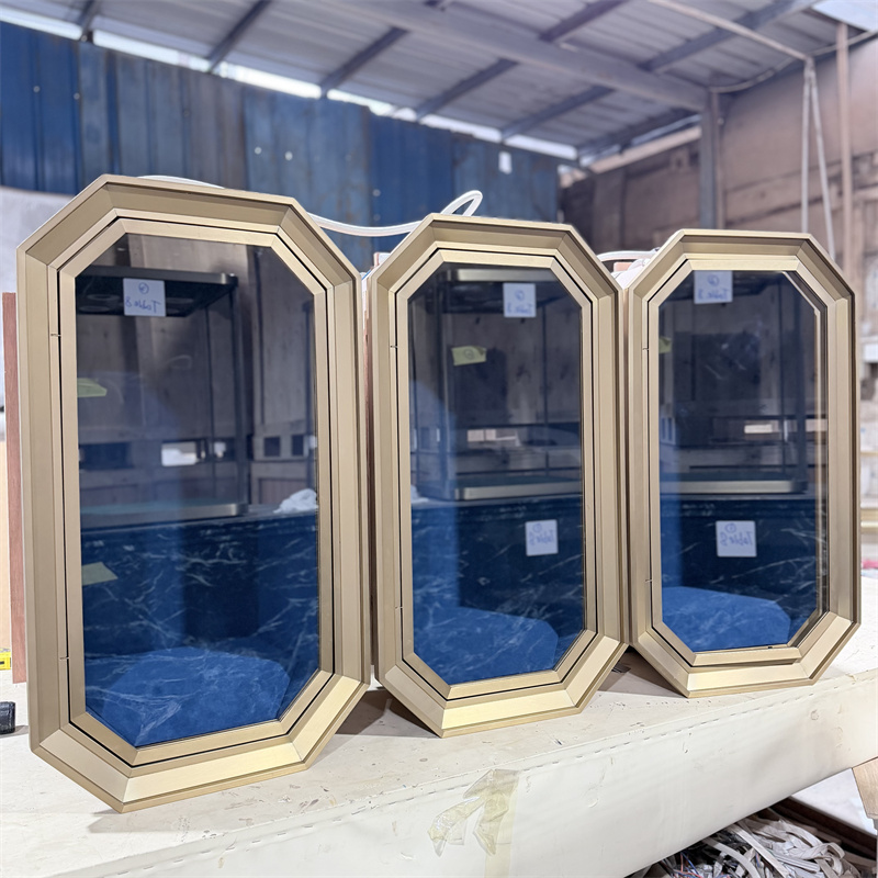 A row of wall-mounted octagonal jewelry showcase displays with gold frames and blue velvet lining in a workshop